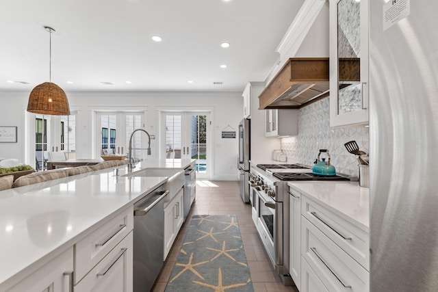 kitchen featuring pendant lighting, stainless steel appliances, white cabinets, custom exhaust hood, and french doors