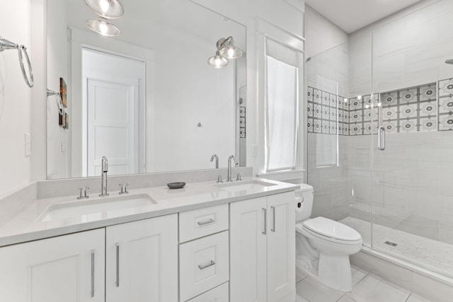 bathroom featuring a shower with shower door, toilet, tile patterned flooring, and dual bowl vanity