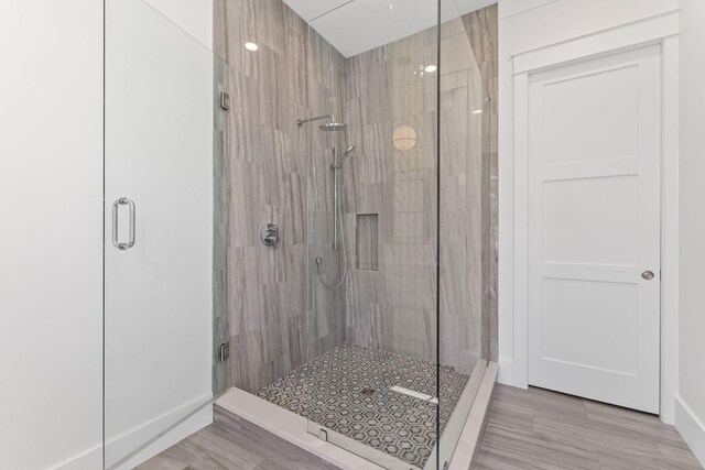 bathroom with an enclosed shower and tile patterned floors