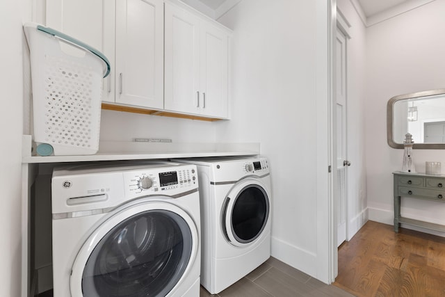 washroom featuring dark wood-type flooring, cabinets, and washing machine and clothes dryer