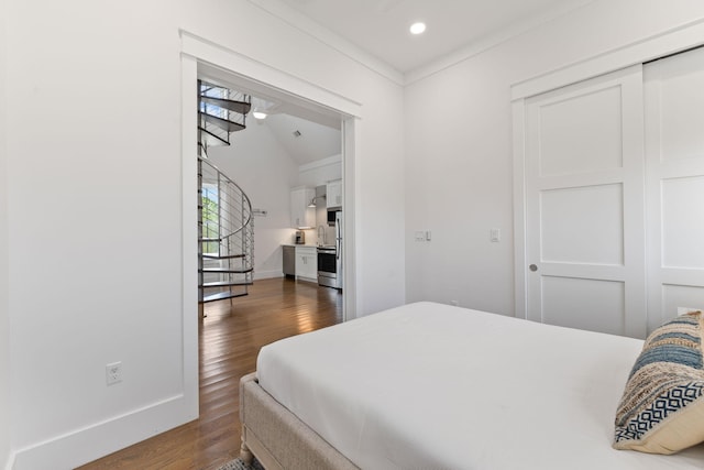 bedroom with dark wood-type flooring, vaulted ceiling, and a closet