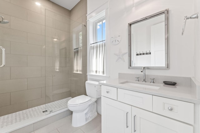 bathroom featuring tile patterned floors, toilet, vanity, and an enclosed shower