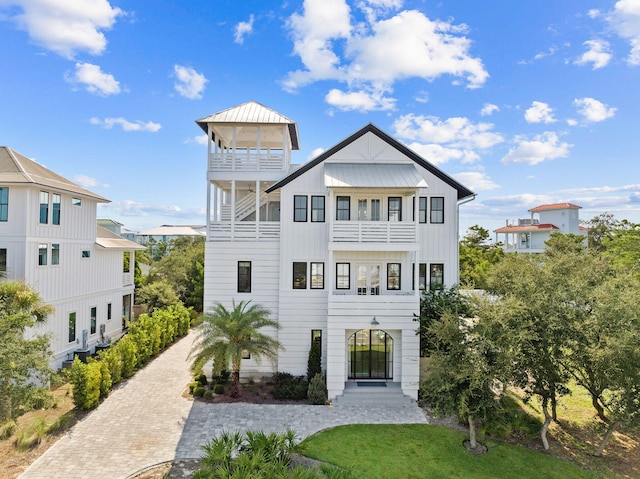 back of property with a balcony and a lawn