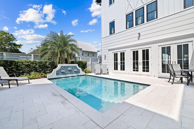 view of swimming pool with french doors, pool water feature, and a patio