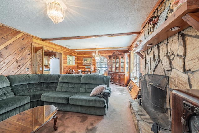 living room featuring beam ceiling, wooden walls, a chandelier, and a textured ceiling