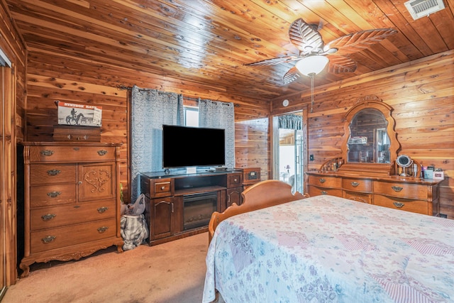 carpeted bedroom with wooden ceiling, wood walls, and ceiling fan