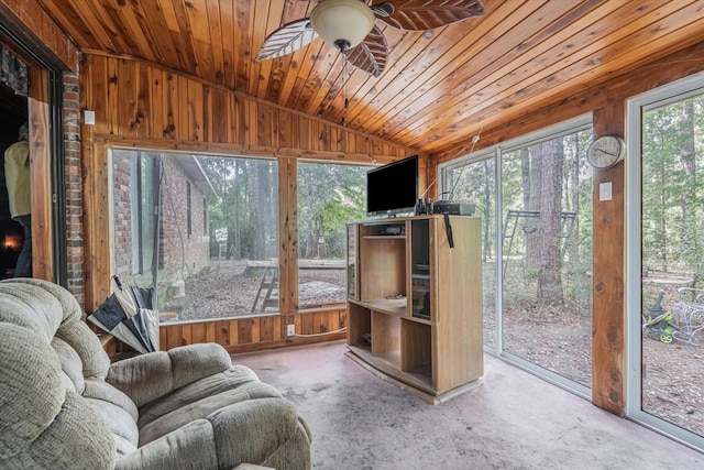 sunroom / solarium featuring a healthy amount of sunlight, wood ceiling, ceiling fan, and vaulted ceiling