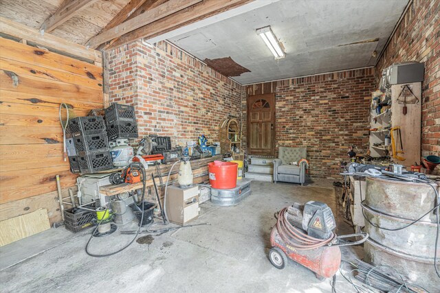 interior space featuring brick wall and concrete flooring