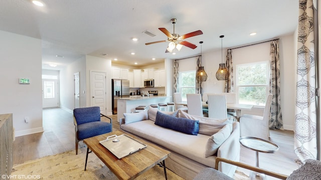 living room featuring ceiling fan and light hardwood / wood-style flooring