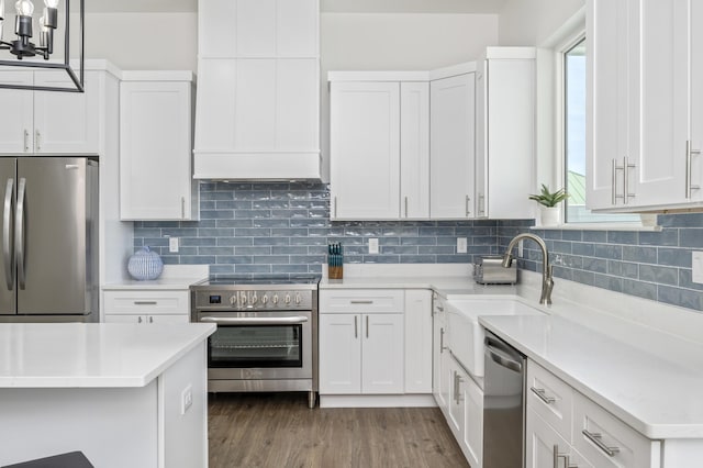 kitchen featuring stainless steel appliances, a wealth of natural light, white cabinets, and a sink