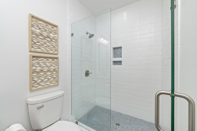 full bath with toilet and a tile shower