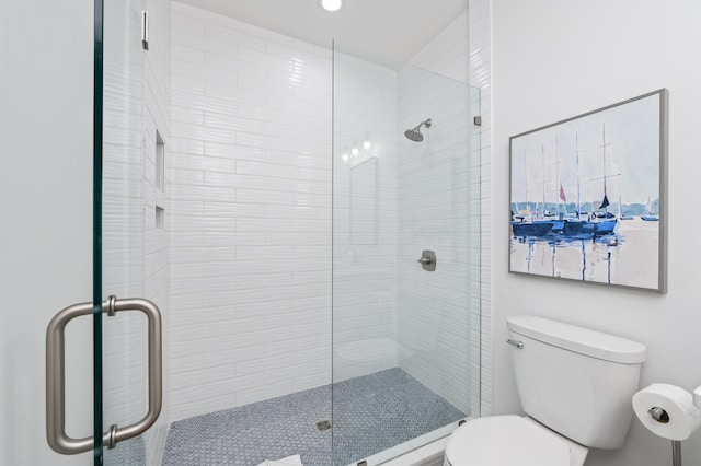 full bathroom with a tile shower and toilet