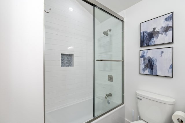 bathroom with combined bath / shower with glass door and toilet