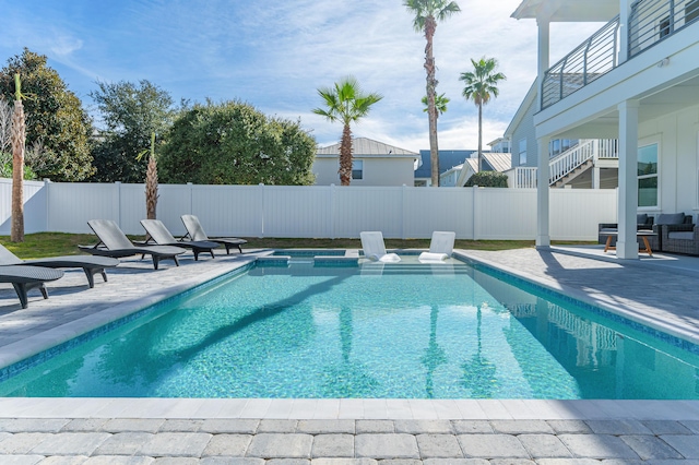 view of pool featuring a patio area, a fenced backyard, and a pool with connected hot tub