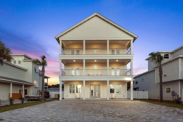 back of property featuring french doors, board and batten siding, and a balcony