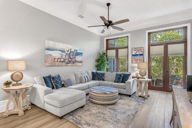 living room featuring crown molding, french doors, light wood-type flooring, and ceiling fan