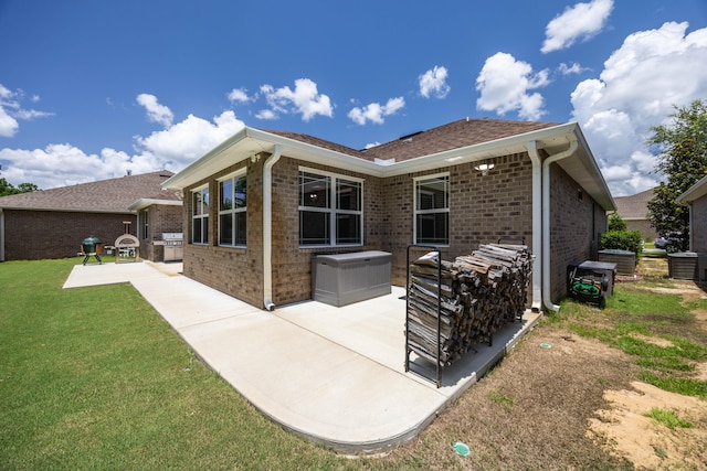 back of house featuring central AC unit, a lawn, and a patio area