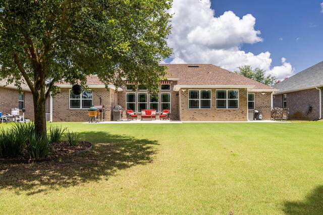 rear view of house featuring a yard and a patio