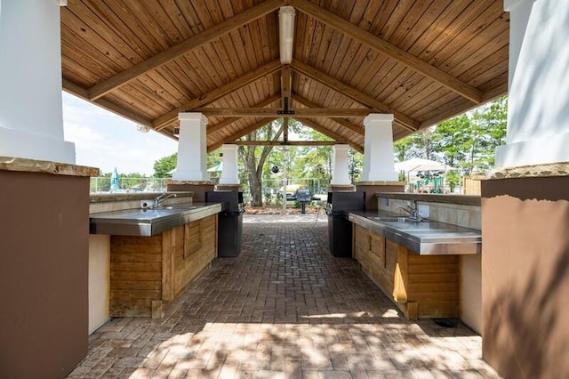 view of patio featuring exterior kitchen, a gazebo, and sink