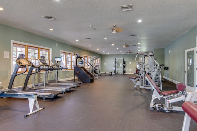 gym featuring a textured ceiling and ceiling fan