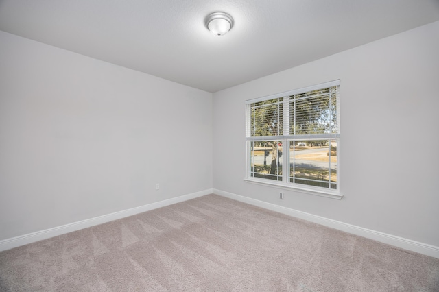 carpeted spare room featuring plenty of natural light