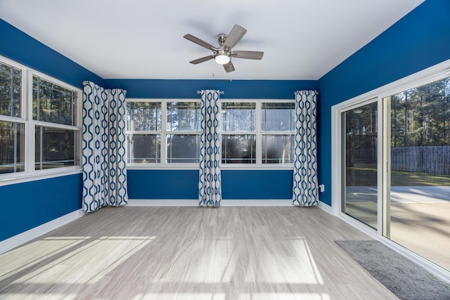 unfurnished sunroom with ceiling fan