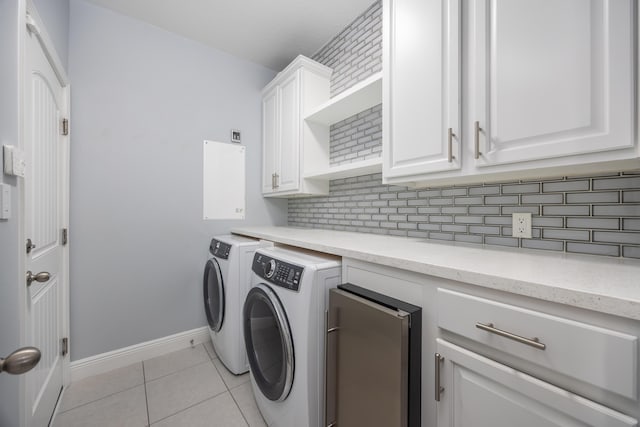 washroom with washer and dryer, cabinets, and light tile patterned flooring