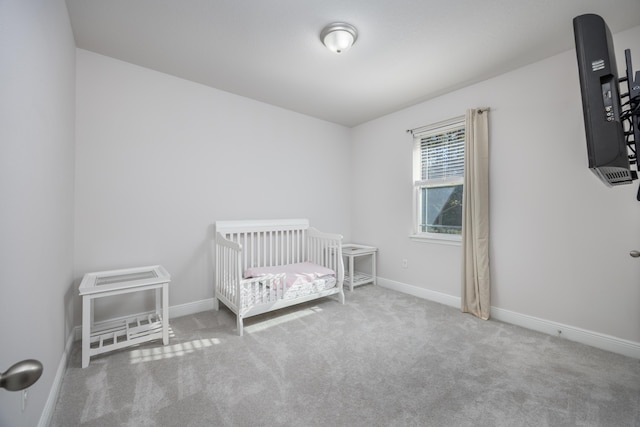 unfurnished bedroom with a crib and carpet