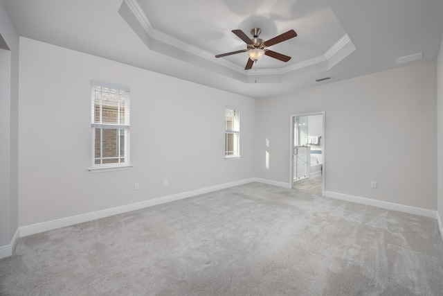 carpeted spare room featuring ceiling fan, ornamental molding, and a tray ceiling