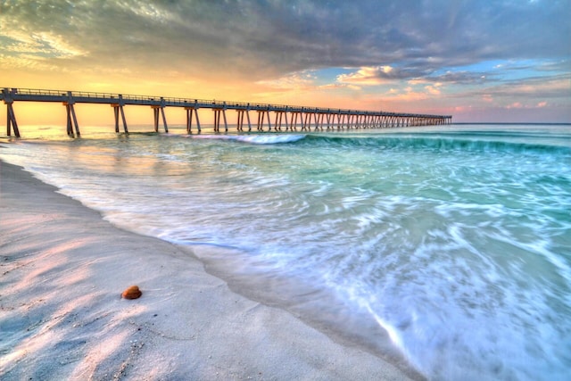 property view of water featuring a pier and a view of the beach