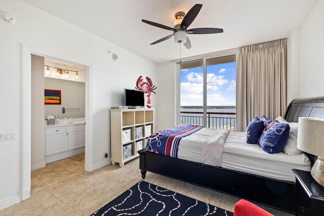 bedroom with baseboards, floor to ceiling windows, ensuite bath, a textured ceiling, and access to outside