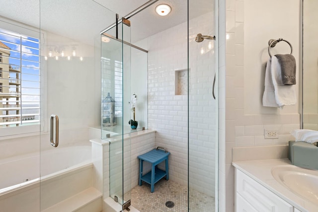 bathroom with vanity, a shower stall, and a textured ceiling