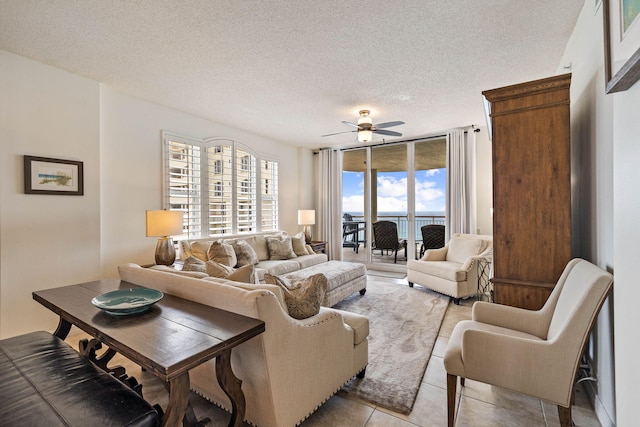 living room featuring a textured ceiling, light tile patterned flooring, and a ceiling fan