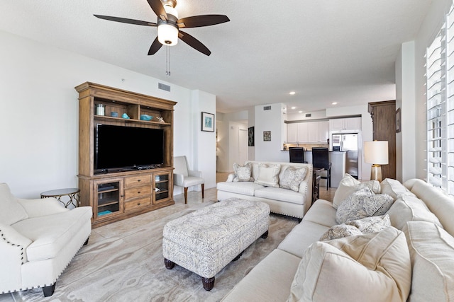 living area featuring visible vents, recessed lighting, a textured ceiling, and a ceiling fan