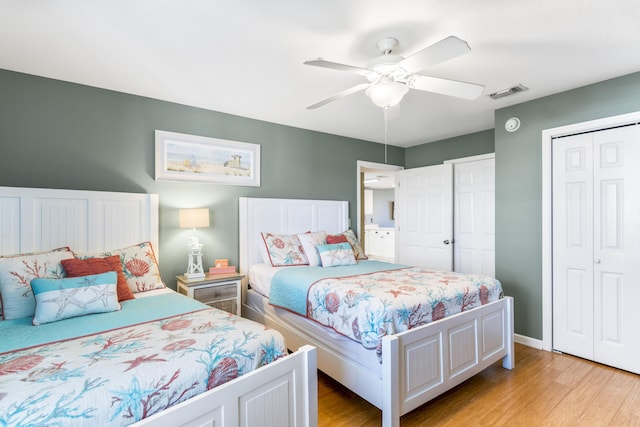 bedroom with light wood-style flooring, a closet, visible vents, and a ceiling fan