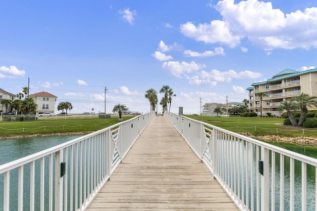 surrounding community featuring a water view, a yard, and fence