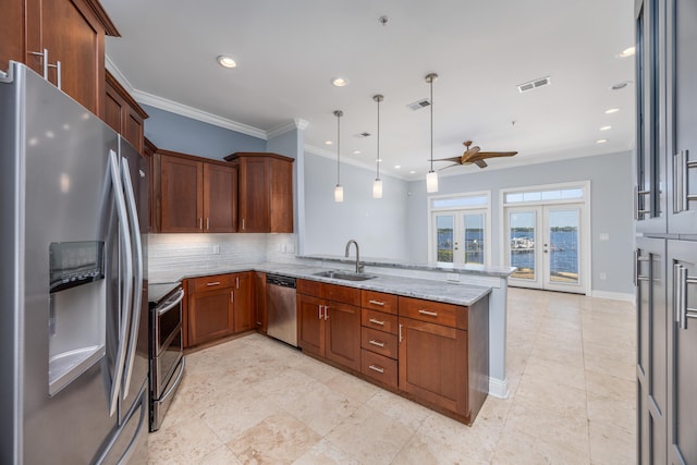 kitchen featuring hanging light fixtures, appliances with stainless steel finishes, sink, and kitchen peninsula