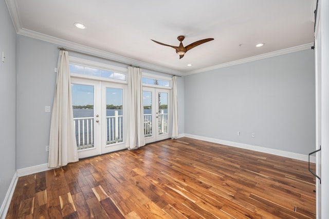 empty room featuring ceiling fan, wood-type flooring, ornamental molding, and french doors