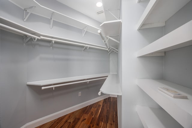 walk in closet with dark wood-type flooring