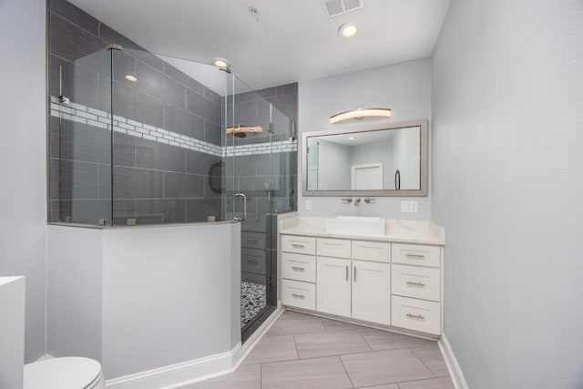 bathroom featuring tile patterned floors, toilet, a shower with door, and vanity