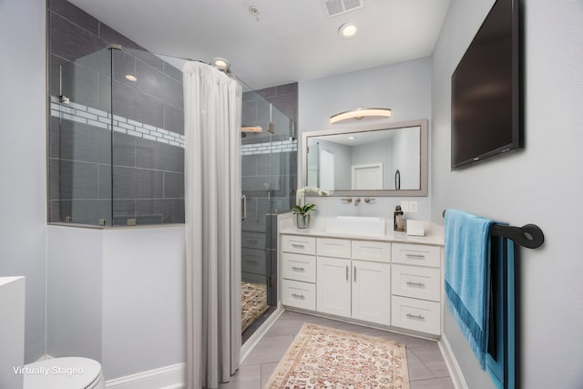 bathroom featuring vanity, a shower with door, and toilet