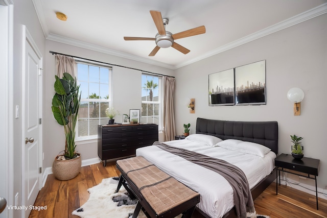 bedroom with ornamental molding, hardwood / wood-style flooring, and ceiling fan