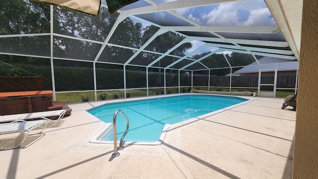 view of swimming pool featuring a patio area, a hot tub, and a lanai