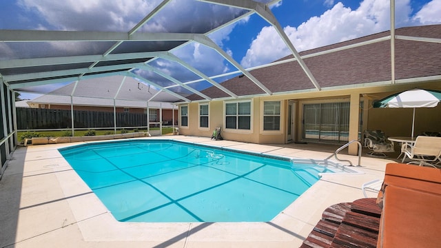 view of swimming pool featuring glass enclosure and a patio area