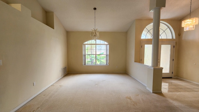 entrance foyer with a notable chandelier, light carpet, decorative columns, and a textured ceiling