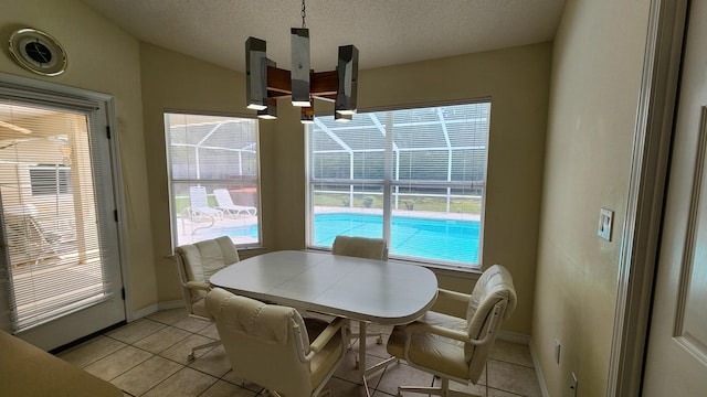 dining space featuring a wealth of natural light, vaulted ceiling, and light tile patterned floors