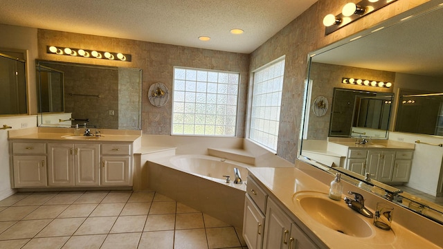 bathroom with tile patterned floors, shower with separate bathtub, a textured ceiling, and vanity