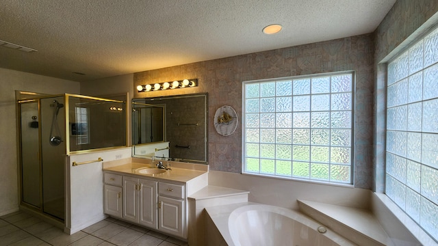 bathroom with plus walk in shower, vanity, tile patterned floors, and a textured ceiling