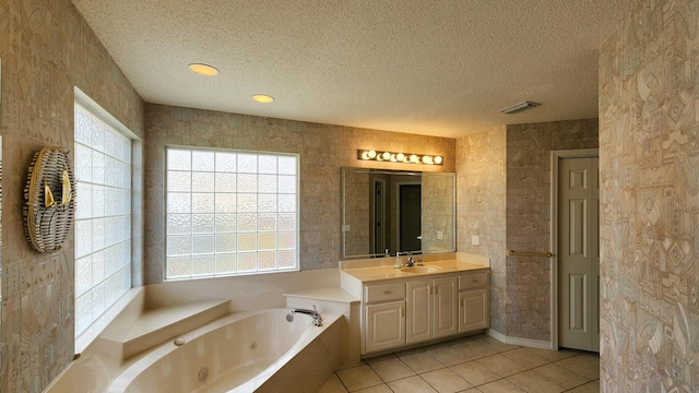 bathroom with tile patterned flooring, vanity, a healthy amount of sunlight, and a textured ceiling