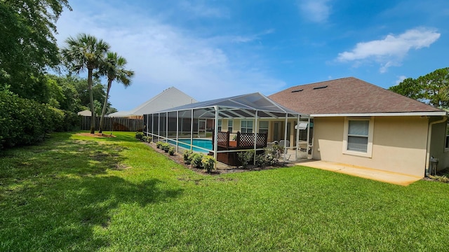 rear view of house with a yard, a lanai, a fenced in pool, and a patio